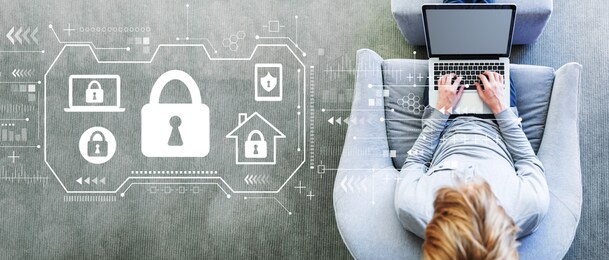 security theme with man using a laptop in a modern gray chair