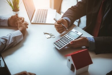 real estate agent calculate insurance fee for house and show to young couple. business successful contract concept.