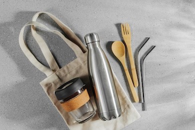 set of eco friendly bamboo cutlery, eco bag and reusable coffee mug. sustainable lifestyle. plastic free concept.