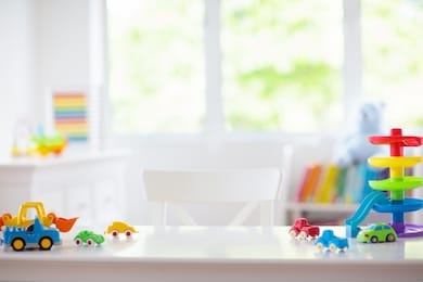 little boy room. desk with colorful toy cars. nursery for young kid with educational vehicle and transport toys. plastic car at rainbow parking garage. home or kindergarten interior. 