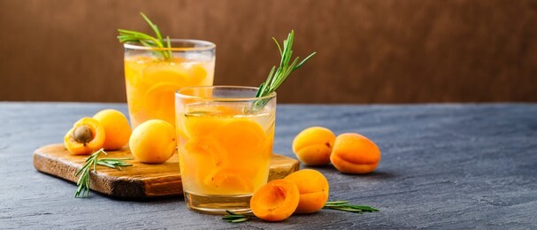 summer drinks, rosemary aprcot cocktails with ice in glasses. refreshing summer homemade alcoholic or non-alcoholic cocktailsor detox infused flavored water. space for text. long wide banner