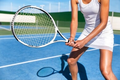 tennis player woman ready playing game on blue hard court holding racket in position wearing white dress skirt. female athlete sport girl in summer sports activity class.