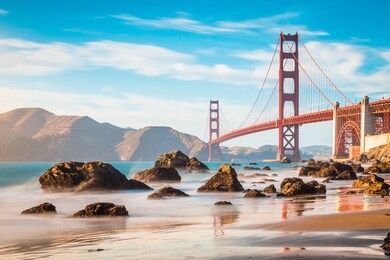 classic panoramic view of famous golden gate bridge seen from scenic baker beach in beautiful golden evening light on a sunny day with blue sky and clouds in summer, san francisco, california, usa