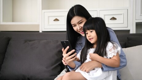 communication concepts. mother and daughter are watching tv programs on the internet.