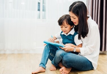 child kid boy son kindergarten and beautiful mother teaching drawing together at interior room home