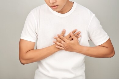 asian man having tight chest from heart attack, white background , sick person concept