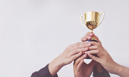 hand of team business holding a golden trophy, concept teamwork