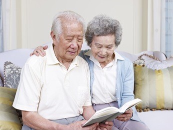senior asian couple reading a book together at home.