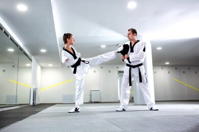 physically challenged young woman in sports practicing taekwondo and training hard