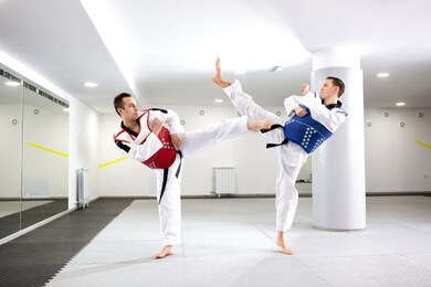 two guys in a taekwondo combat pushing themselves to their limits