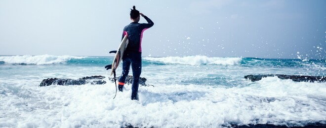 woman surfer with surfboard going to surf