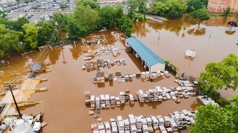 extreme flooding in historic town overflowing creek and damaged homes and businesses aerial drone of mount holly new jersey