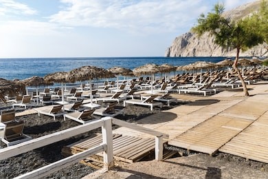 kamari beach, santorini. volcanic sand beach and mountain of kamari beach, santorini, greece