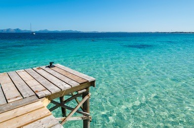 wooden pier turquoise sea water sunny day, alcudia beach, majorca island
