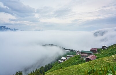 pokut plateau and traditional wooden houses are under sea of clouds. landscape photo was taken at pokut plateau, rize, northeastern karadeniz (black sea) region of turkey.