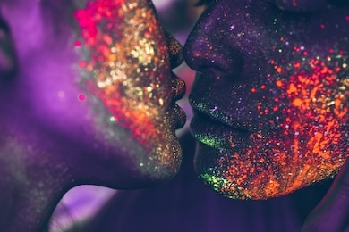 couple kissing in the disco club with fluorescent paintings on the faces