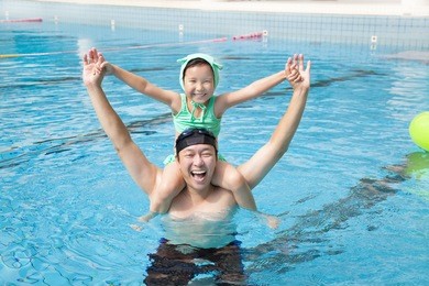 happy father and little girl in the swimming pool