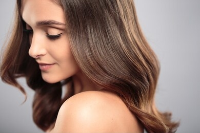 brunette girl with healthy curly hair and natural make up . beautiful model woman with wavy hairstyle .care and beauty