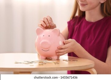 teen girl with piggy bank and money at home, closeup