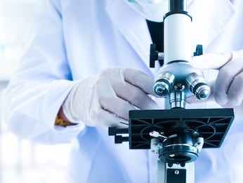 scientist use microscope for experiment research test about biotechnology close up hand in laboratory