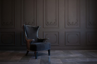 stylish black chair against a dark gray wall. stylish chair on wall background, copy space, fashionable interior