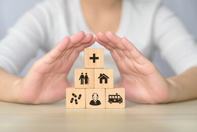 hand arranging wood block stacking with icon related to elderly health care, the wooden block with different icon of medical service for elderly people.