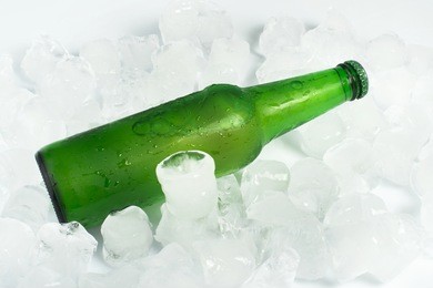 green bottle of beer and ice cubes