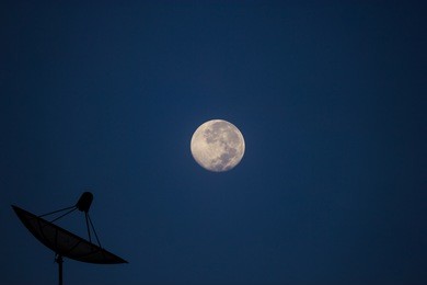 satellite dish in evening sky with moon