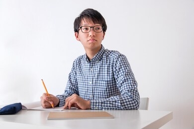 portrait of a junior high school boy in front of a white wall
