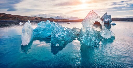 view from flying drone of floating of blue icebergs in jokulsarlon glacier lagoon. attractive summer sunrise in vatnajokull national park. stunning morning scene of iceland, europe.