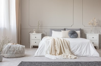 cozy cream colored woolen blanket on king size bed in bright bedroom