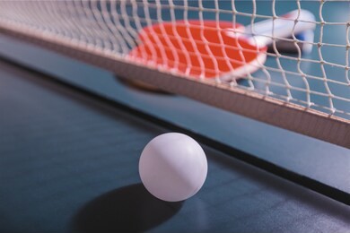 table tennis rackets and ball on table with net