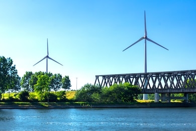 wind turbines beside a bridge
