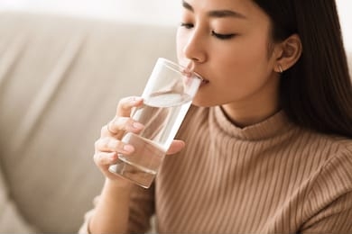 healthy liquid. asian girl drinking clean water from glass, free space