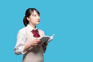 asian high school girl reading a book.