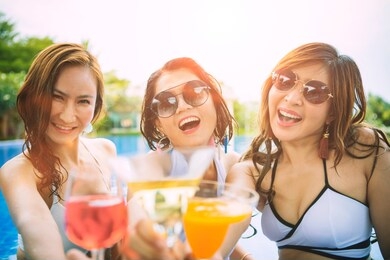 three younger asian woman happiness drinking beverage in waer swimming pool