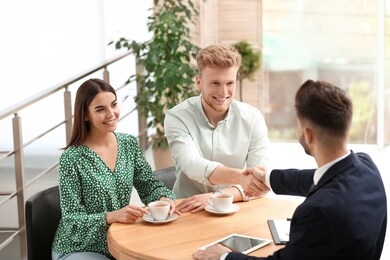 insurance agent shaking hands with client in office