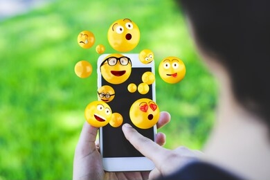 close-up of woman using smartphone sending emojis. social concept.