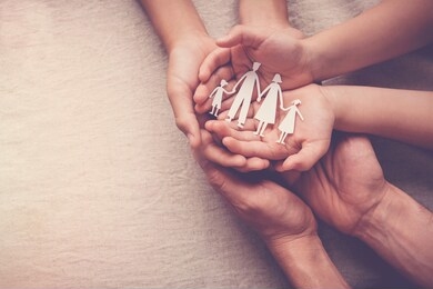 adult and children hands holding paper family cutout, family home, foster care, homeless support, international day of families concept
