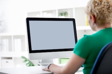 rear view closeup of a young woman working of a computer