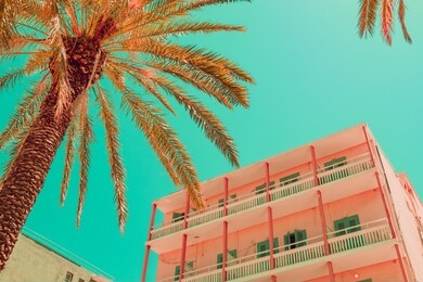 beach hotel and palms in infrared style. tropical travel concept. minimalism and surreal. soft light orange and green colors