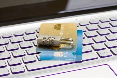 internet transaction security concept   - plastic cads with padlock on laptop keyboard