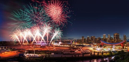fireworks display over the night sky with the calgary downtown skyline in the backdrop during the annual stampede festivities.