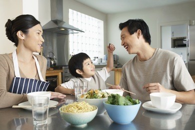 happy young family enjoying meal at the kitchen table in house