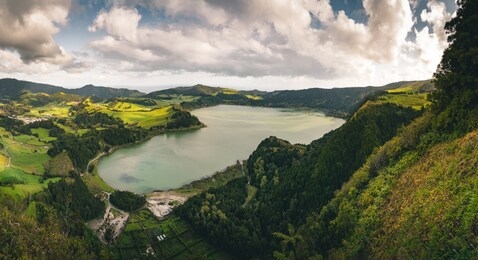 panoramic landscape with aerial view on beautiful blue green crater lake lagoa das furnas and village furnas with vulcanic thermal area. sao miguel, azores, portugal. countryside landscape with green