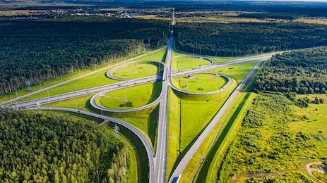 aerial view of highway in city. cars crossing interchange overpass. highway interchange with traffic. aerial bird's eye photo of highway. expressway. road junctions. car passing. top view from above.