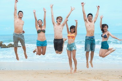portrait of jumping friends on the beach