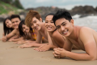 portrait of a group of friends sun bathing together on the beach
