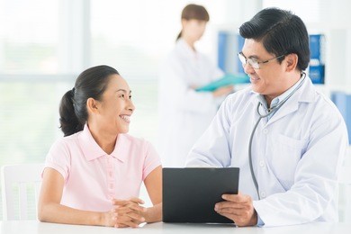 image of a smiling doctor consulting his older patient on the foreground
