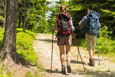 sporty hikers on path with trekking poles